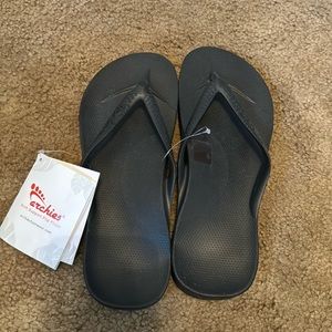 Archie’s black flip flops